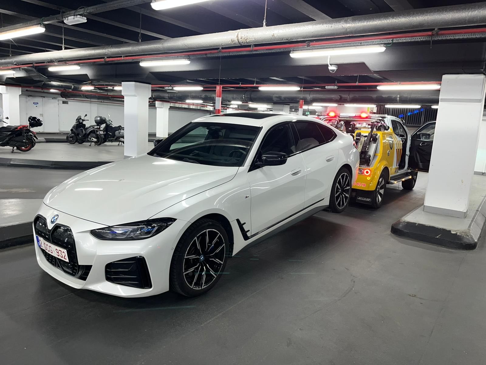 Dépannage en parking souterrain à Anderlecht — BMW i4 blanche tractée par la dépanneuse ABD